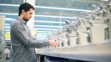 Sıhhi teknik Dükkanı. Musluklar ve adam Müşteri satırları.