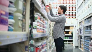 Adam boya Dükkanı. Boya kutuları raflara satırları.