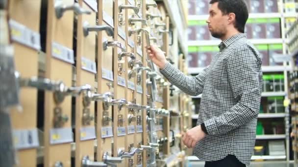 Mann wählt Türklinken in Baumarkt — Stockvideo