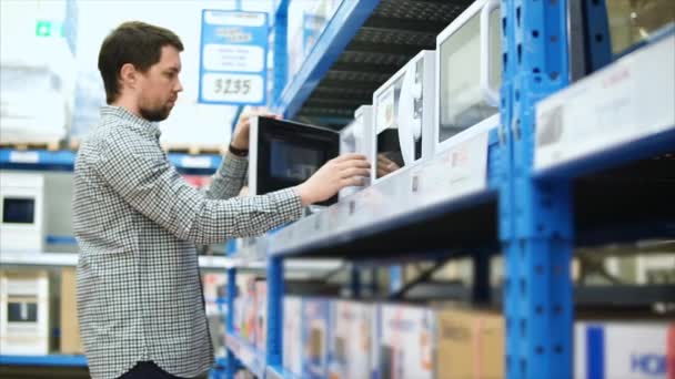 Muž chce koupit mikrovlnnou troubu v obchodě domácích spotřebičů — Stock video