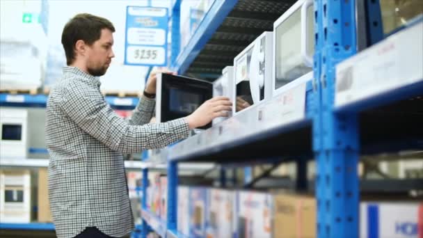 Man wil kopen van een magnetron over in de shop van huishoudelijke apparaten — Stockvideo