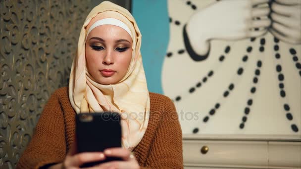Современная арабская женщина в хиджабе общается на мобильном телефоне онлайн с друзьями — стоковое видео