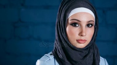 Hicap giyinmiş bir Müslüman kadın doğruca kameraya benziyor