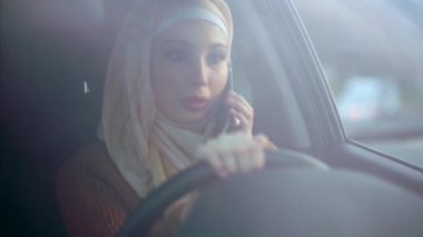 Müslüman kadının araba yolculuk sırasında cep telefonundan olduğunu