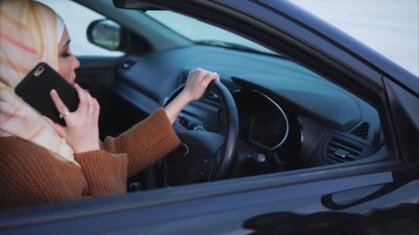 Mujer musulmana moderna que tiene una charla de teléfono móvil y va a viajar en coche — Vídeos de Stock