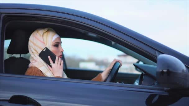 Muslimská žena je na buňku v autě — Stock video
