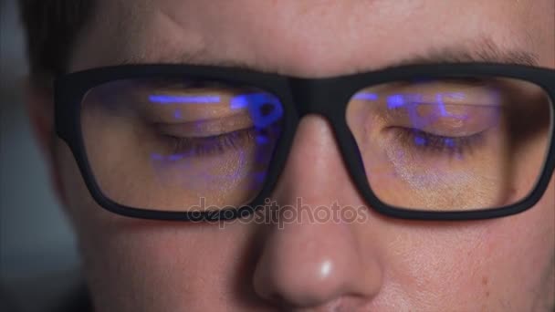 Крупным планом снимок глаз человека в очках, который смотрит фильм — стоковое видео
