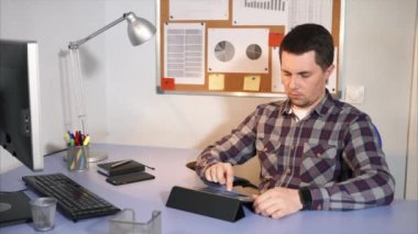 Onun ofisinde oturan tablet gelen postaları kontrol işadamı.