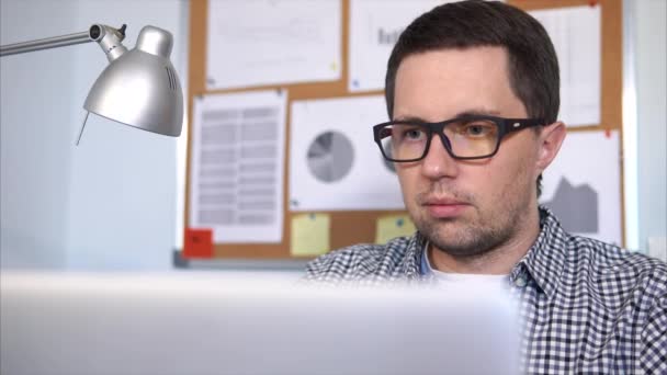 Бізнесмен сидить на робочому місці і працює зі своїм ноутбуком . — стокове відео