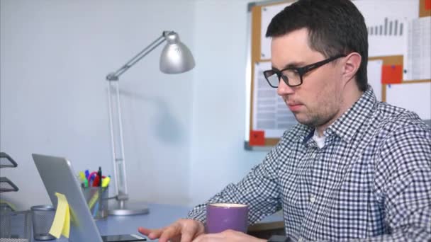 Менеджер, який вводить текст на ноутбуці, сидить на своєму робочому місці . — стокове відео