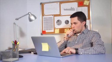 Genç adam bir elektronik sigara veya vaping ofiste Sigara.