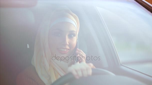 Concept van moderne hijab. Gelukkig Moslimvrouw in een auto op een stoel van stuurprogramma 's. — Stockvideo