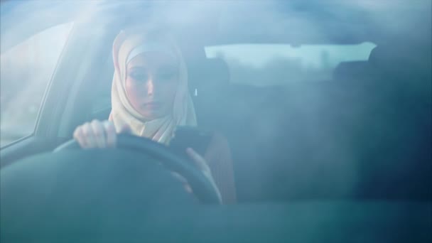 Conductora musulmana moderna hablando en móvil, vista a través del parabrisas — Vídeos de Stock