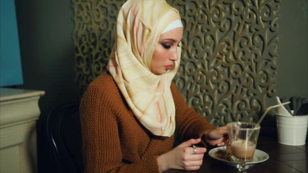 Muslim woman eating a dessert with coffee in cafe — Stock Video