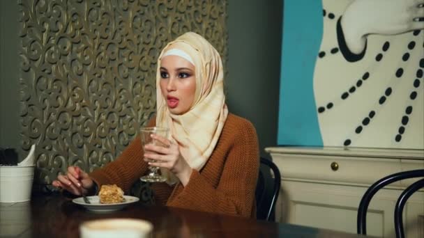 Mulher muçulmana no hijab come sobremesa no café . — Vídeo de Stock
