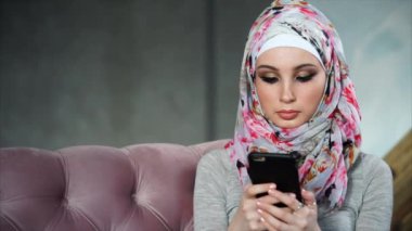 Smartphone ile modern Müslüman kadın. Modern parlak renkli hijab kavramı