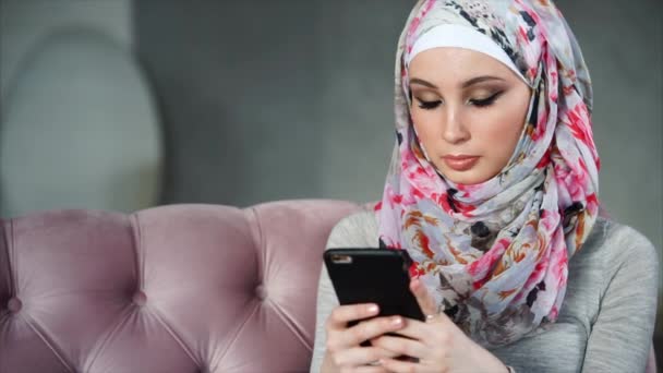 Een moderne Arabische vrouw communiceert op haar mobiele telefoon online met haar vrienden — Stockvideo
