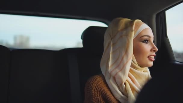Счастливая мусульманка, наслаждающаяся поездкой на такси по городу — стоковое видео