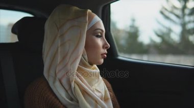 Bir araba bir yolcu koltuğu üzerinde ciddi Arap kadın. Bir arabaya biniyor
