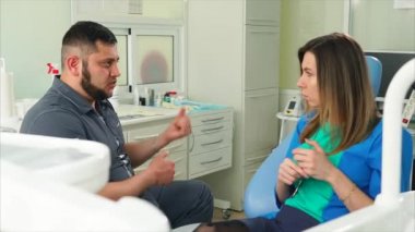 Kadın hasta konuşurken diş hekimi