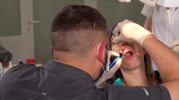Tandarts verstrekken van gebit reinigen voor een vrouw-patiënt — Stockvideo