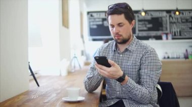 Yetişkin bir adam bir kahve evde oturan telefonda iletişim kurar