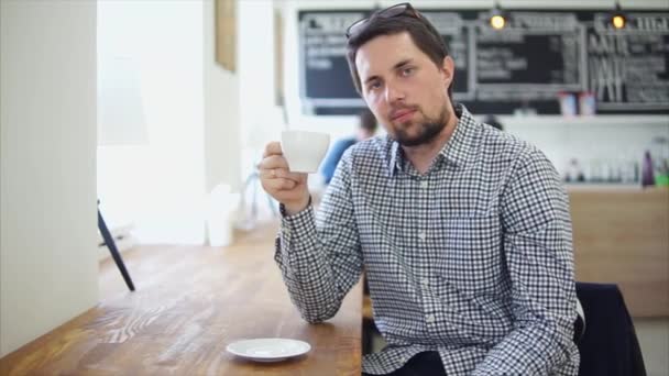 Mannelijke café bezoeker genieten van kopje koffie. Hij houdt het — Stockvideo