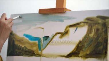 Gökyüzüne denize yakın açık havada boyayan bir kadının elleri görüntüsünü kapatmak