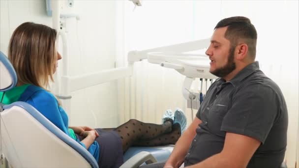Ортодонт проводит первичную консультацию для женщины, которая пришла на лечение — стоковое видео