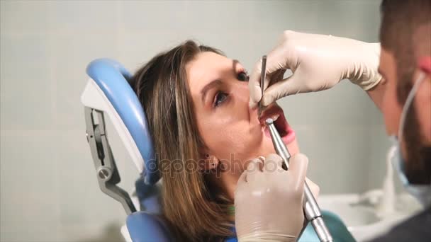 Doktor diş hekimi diş plak ve tartar gelen genç kadın için temizler — Stok video
