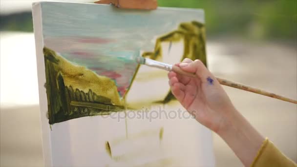 Vista de cerca del lienzo y la imagen sin terminar. Mujer pintora — Vídeo de stock
