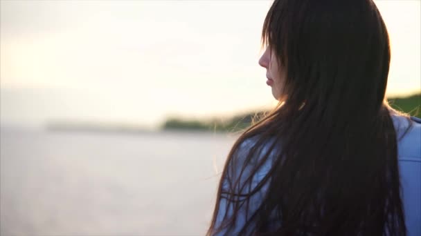 Leuke romantische vrouw in de buurt van het meer in de avond. — Stockvideo