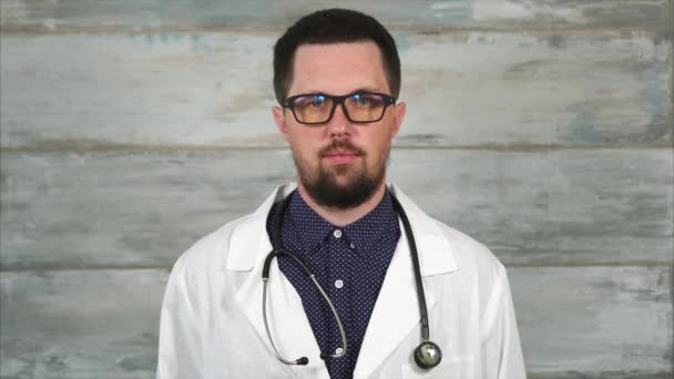 Retrato del médico varón adulto con estetoscopio en bata blanca y gafas . — Vídeos de Stock