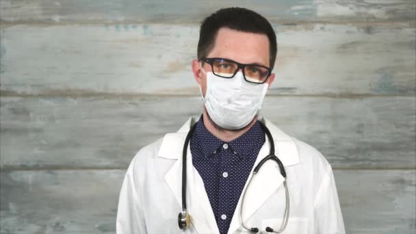 Un hombre de mediana edad con una bata médica blanca y un estetoscopio en el cuello — Vídeo de stock