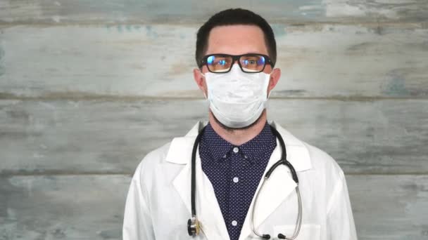 Ο γιατρός ο άνθρωπος σε ένα λευκό φόρεμα ιατρική και ένα στηθοσκόπιο στο λαιμό του — Αρχείο Βίντεο