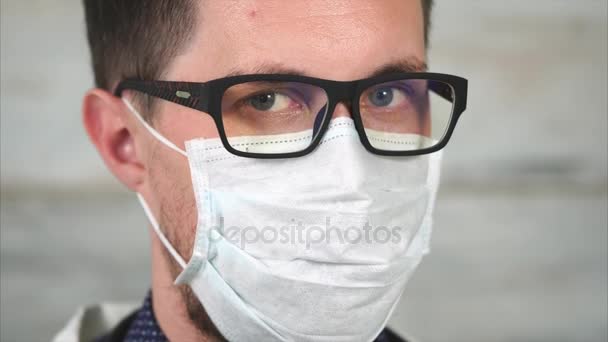 Retrato de un joven que lleva gafas y una máscara de trapo en la cara — Vídeos de Stock