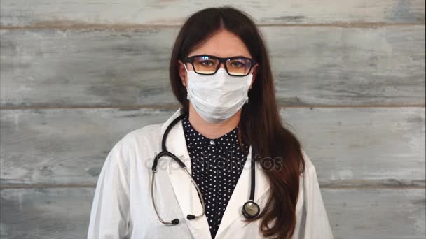 Medico donna adulta con stetoscopio in mantello bianco e maschera protettiva — Video Stock