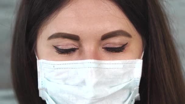 Close up shot of the eyes of a woman who wore a protective mask on her mouth — Stock Video