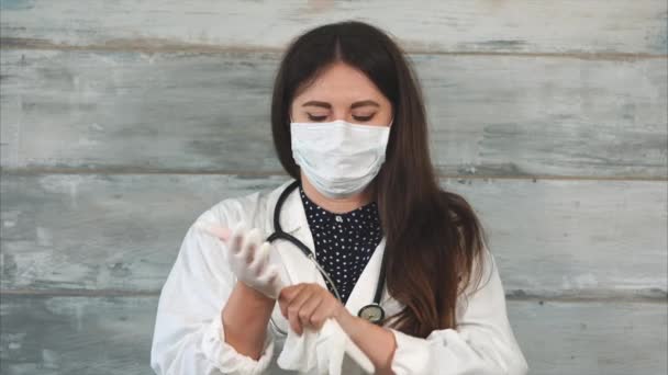 Женщина-врач надевает перчатки перед медицинским осмотром — стоковое видео