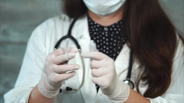 Médico femenino con jeringa y ampolla. Ella abre la ampolla y llena la jeringa — Vídeos de Stock