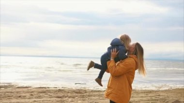 Mutlu bir aile. Küçük kızı tutan genç güzel anne