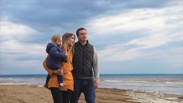 Rodiče s malou dcerou, chůze u moře na chladný den — Stock video