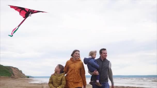 Familia feliz con dos niños caminando por la playa — Vídeo de stock