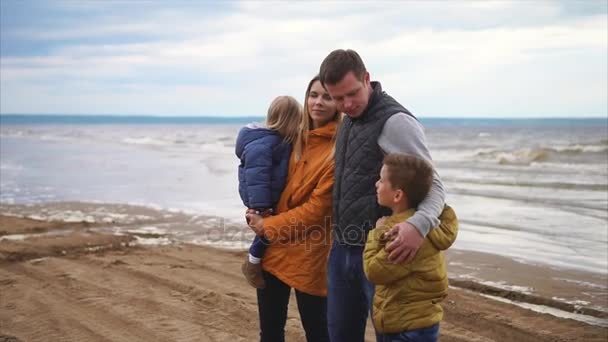 Дружелюбная семья отдыхает у моря, наслаждаясь компанией друг друга — стоковое видео