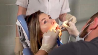 Diş hekimi diş bir kadın hasta için temizlik sağlayan