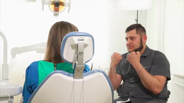 Ортодонт проводит первичную консультацию для женщины, которая пришла на лечение — стоковое видео
