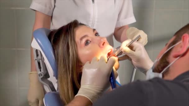 提供清洁的女病人牙齿的牙医 — 图库视频影像