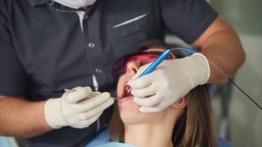 Diş hekimi diş tedavi sağlamak için lazer kullanılarak