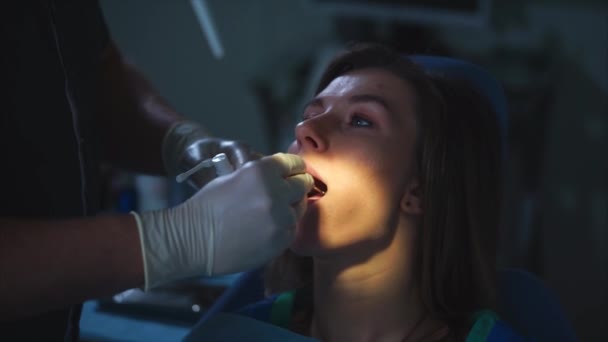 Стоматологическая процедура. Стоматолог с помощью спрея в рот пациента — стоковое видео