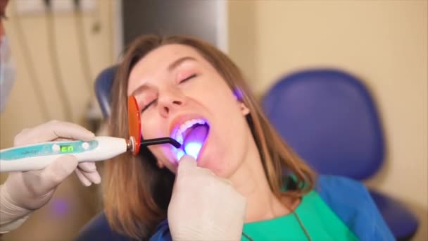 Οδοντίατρος χρησιμοποιώντας λαμπτήρα υπεριώδους στα δόντια των ασθενών. — Αρχείο Βίντεο
